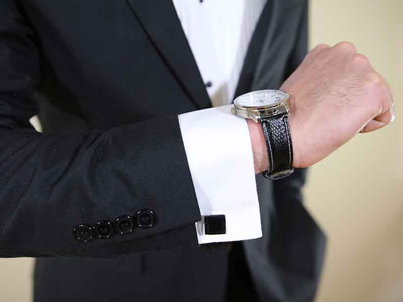 Professional model showing the pose of custom made suite with cufflink wearing watch.